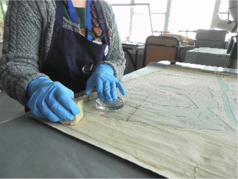 Conservator wearing gloves while treating a map | Image: National Archives of Ireland